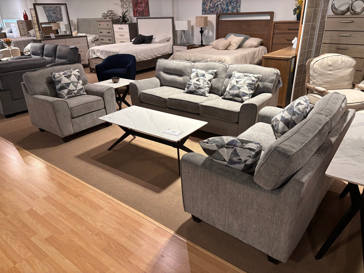 Model 8416 grey living room set with sofa, loveseat, chair, patterned cushions, and coffee table in showroom