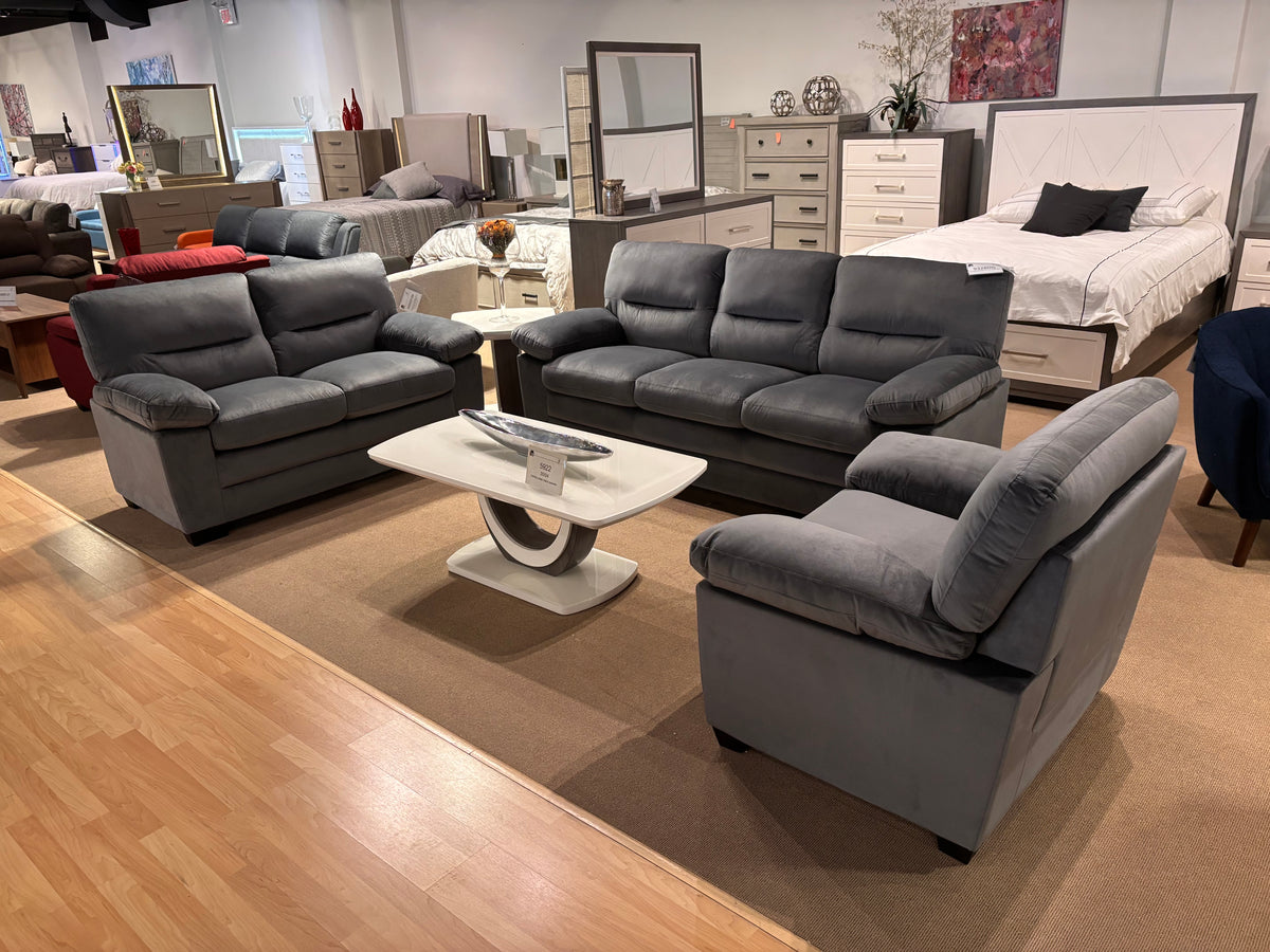 Model 9328DG dark grey living room set with sofa, loveseat, chair, and modern white coffee table in showroom