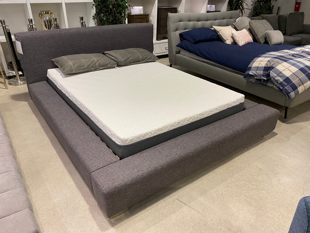 Model 5782DG grey upholstered platform bed shown in a bedroom showroom