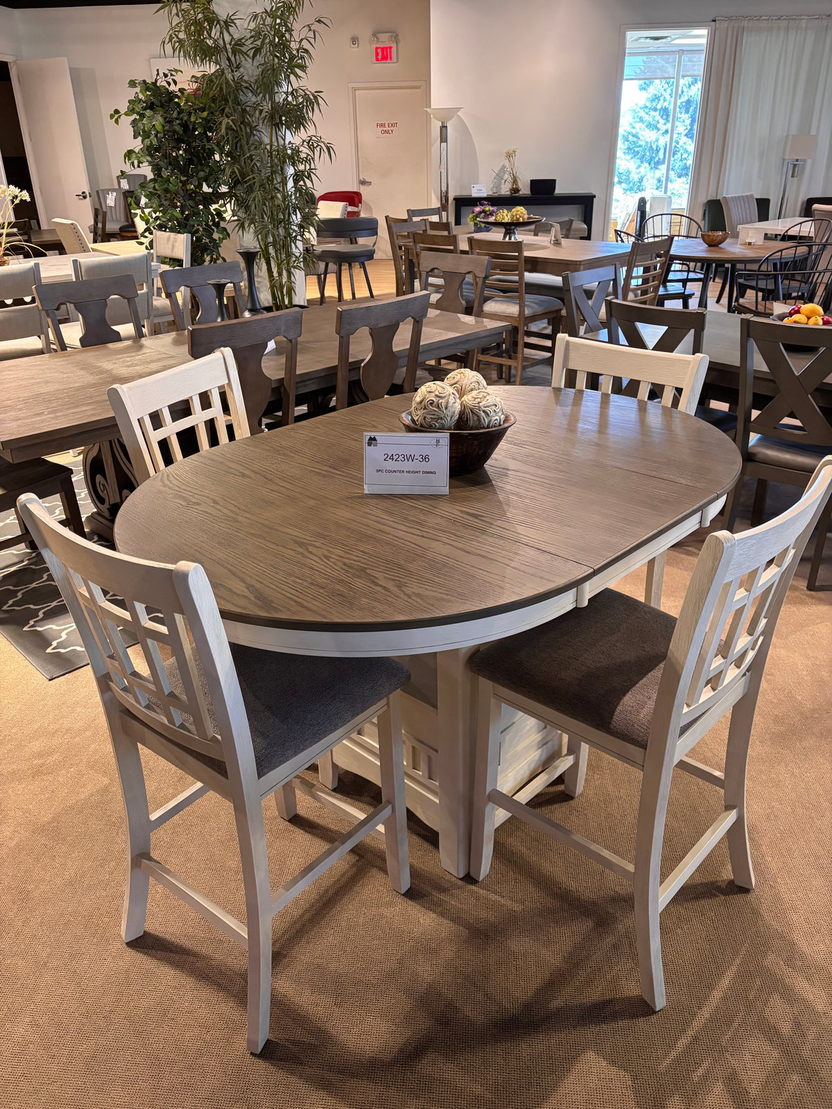 Model 2423W oval counter height dining table with four two-tone chairs