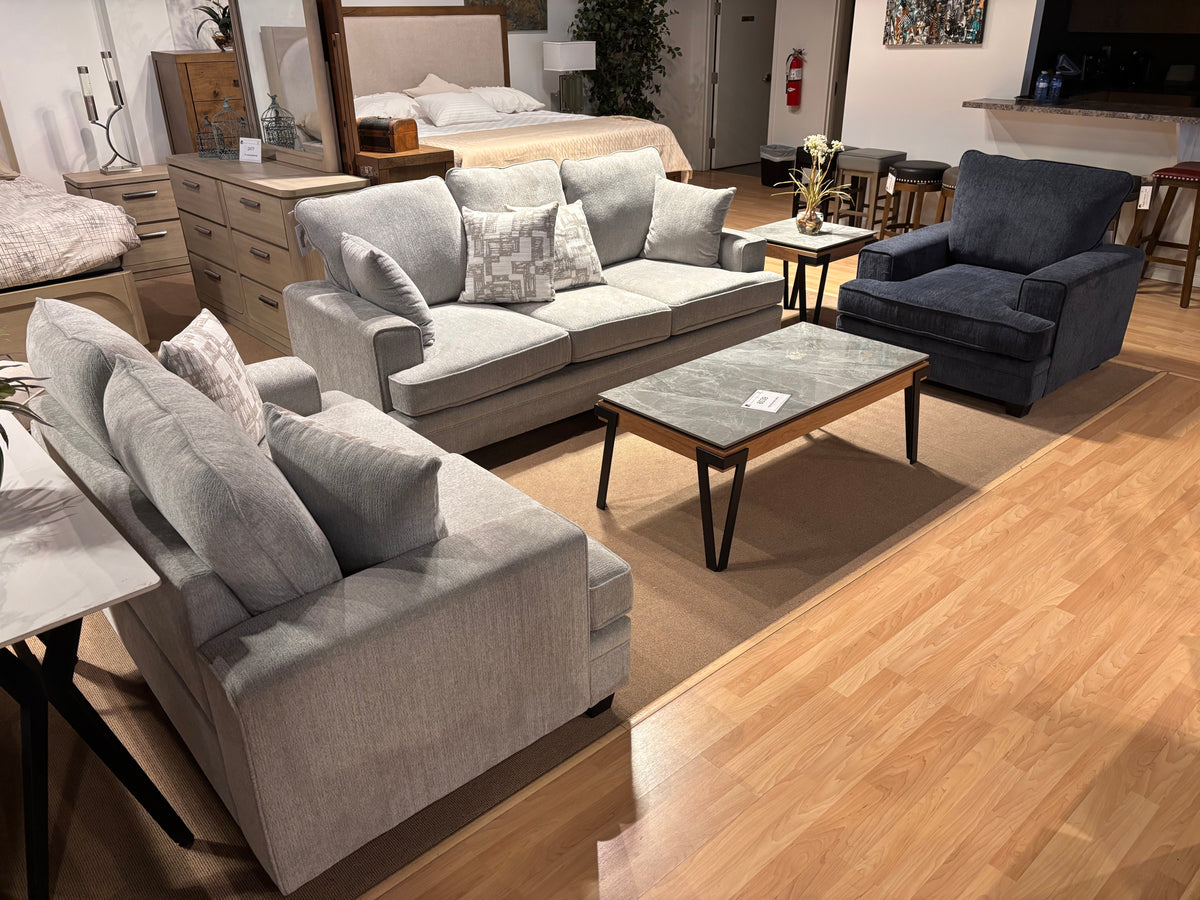 Model 9747 living room set with light grey sofa and loveseat, navy accent chair, and coffee table in showroom