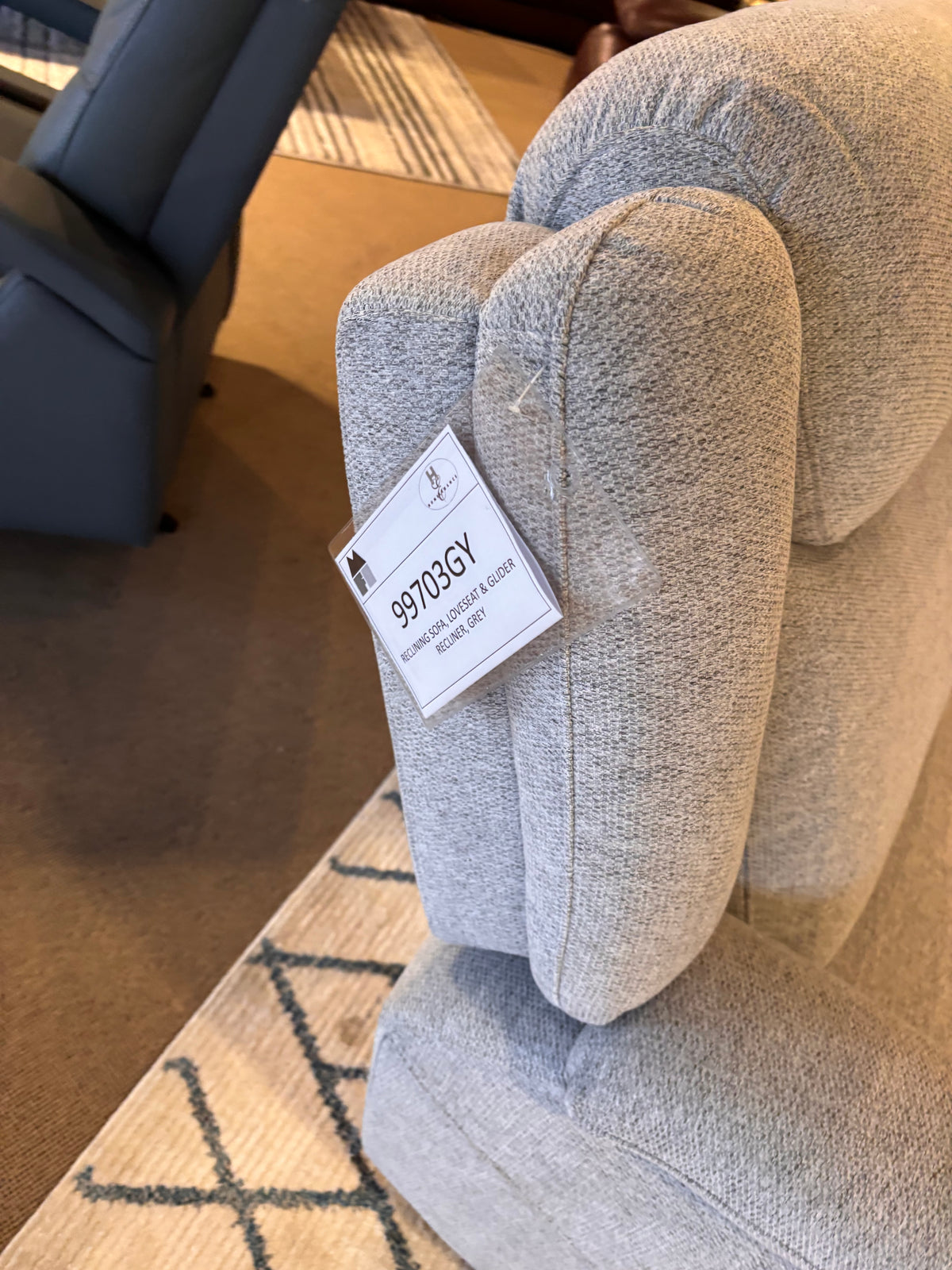 Model 99703GY grey reclining sofa, loveseat, and glider recliner chair in showroom